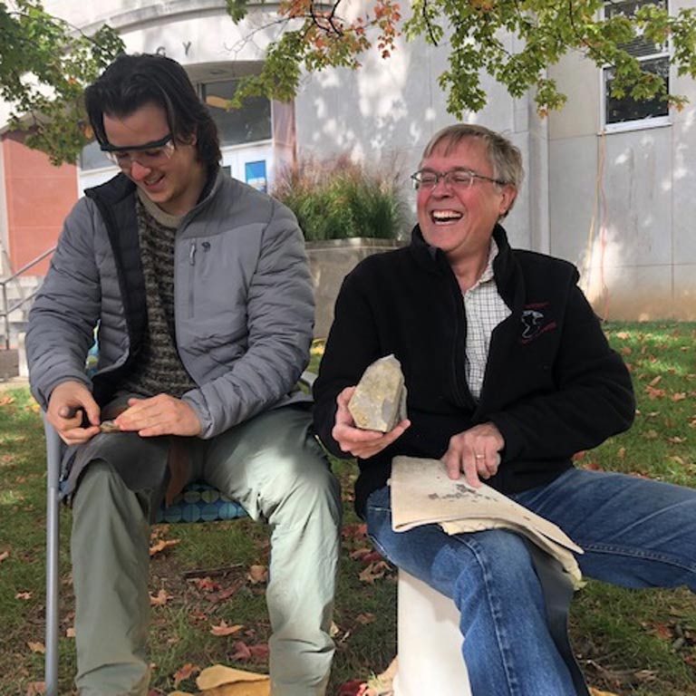 Two men sitting outside laughing