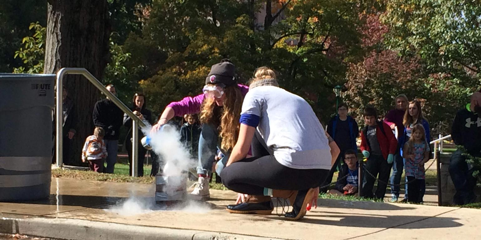 Two students performing an experiment with dry ice