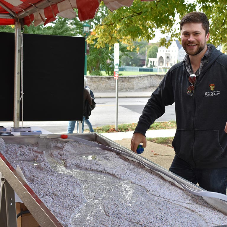 Instructor posing next to a scientific demonstration