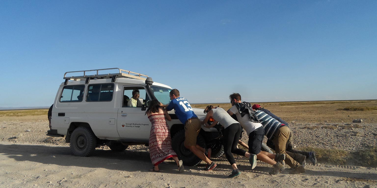 Students pushing a vehicle