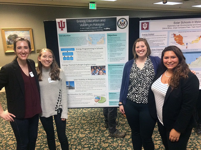 Four females posing in front of research posters